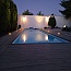 Osvětlený bílý obdélníkový bazén při stmívání