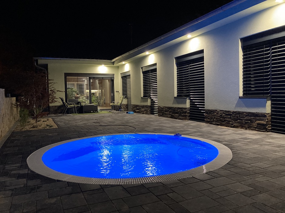 Přelivový kruhový bazén v noci s osvětlením